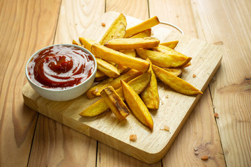 Homemade potato fries on wooden table