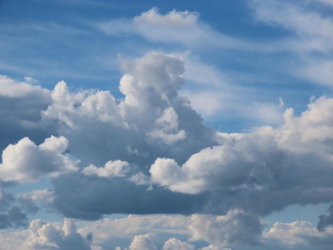 Soft white and grey stratocumulus clouds on a blue sky on a summer day before light rain