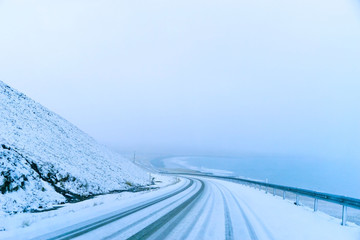 View of the icy road during the snowstorm in winter in Iceland.