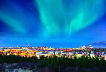 View of the northern light from the city center in Reykjavik, Iceland. - obrazy, fototapety, plakaty