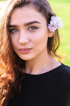 Portrait of woman with pink flower behind her ear