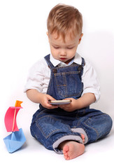 Beautiful baby playing with a smart phone isolated on a white background