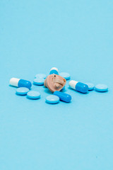 Hearing aid and blue pills on blue background. Medical, pharmacy and healthcare concept. Copy space. Empty place for text or logo