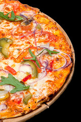 Pizza on a wood board on a black background
