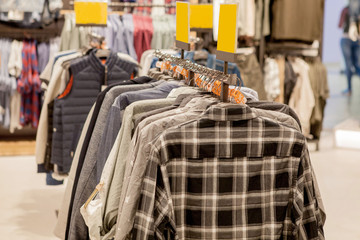 Clothes hang on a shelf . Cloth Hangers with Shirts. Men's stylish clothes. Fashion and trade concept
