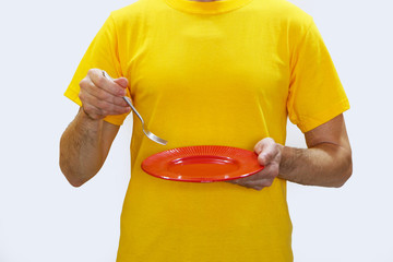 Close-up - a man  eats from a red plate with a metal fork