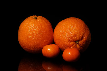 Oranges fruit on a black background with reflection