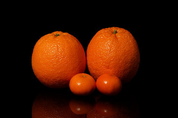 Oranges fruit on a black background with reflection