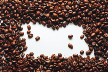 Roasted coffee beans on white background. Copy Space