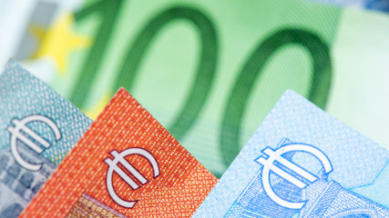 Gros plan de billets de banque avec symboles de la devise euro, un billet vert de 100 euros dans le...