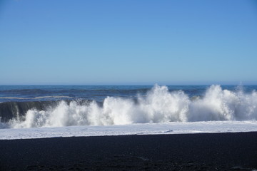 Breathtaking Reynisfjara beach with rocks and blue sky on Iceland in summer