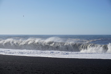 Breathtaking Reynisfjara beach with rocks and blue sky on Iceland in summer