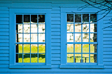 Obraz premium two windows on a blue building reflecting