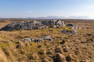 Rocks in a bog with Twelve Bens mountains in background