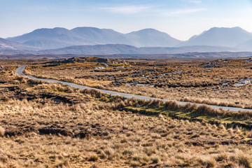 Trail in a bog with Twelve Bens mountains in background