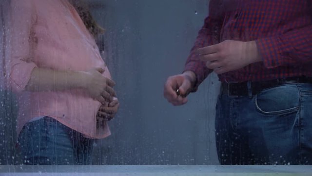 Man leaving engagement ring in front of pregnant wife, family problems, divorce