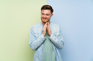 Redhead man over colorful background scheming something