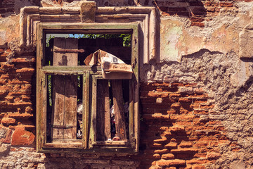 window of a derelict house full of garbage