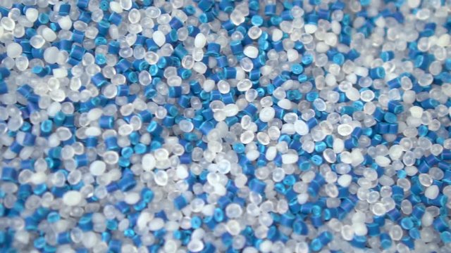 Virgin plastic pellets with blue pigment pellets. Plastic Material for molding machine and plastic injection machine. Industrial engineering concept