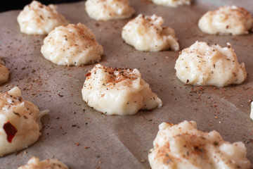 Gougere French pastries on a dripping pan before baking