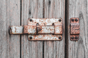 Rusty bolt on the door of a wooden shed close-up