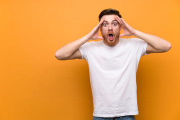 Redhead man over brown wall with surprise expression