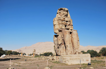 The Colossus of Memnon, massive stone statue of Pharaoh Amenhotep III in West Coast of Luxor, Egypt
