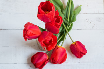 a bouquet of tulips on a wooden table.