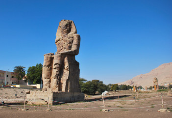 The Colossus of Memnon, massive stone statue of Pharaoh Amenhotep III in West Coast of Luxor, Egypt