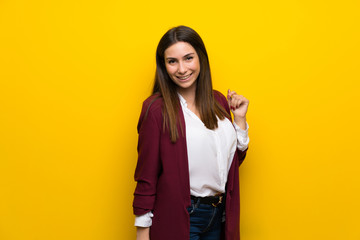 Young woman over yellow wall