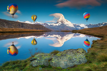 Amazing Matterhorn peak and hot air balloons reflecting in water