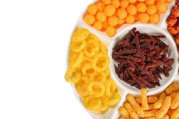 Mix of snacks on a white plate isolated on white.