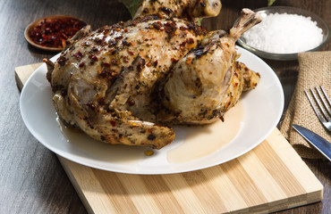 grilled chicken in spices. Spices on the skin, red pepper, sea salt. fork knife. Bouquet of laurel leaf.