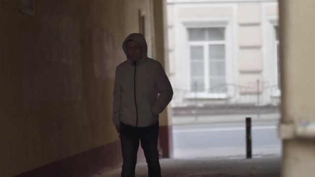 hooligan man in the hood goes on the russian arch on the street