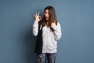 Young sport woman showing ok sign with and giving a thumb up gesture