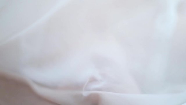A young, beautiful girl is lying on a bed in a nightie. Gentle morning in bed with a girl. A sexy young woman wakes up in the morning on a silk sheet. Pretty girl stroking her beautiful body.