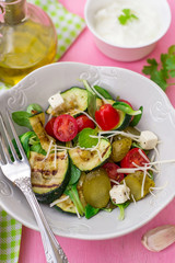 Fresh salad with grilled zucchini, cheese, pickled cucumbers and cherry tomatoes