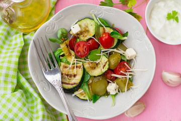 Fresh salad with grilled zucchini, cheese, pickled cucumbers and cherry tomatoes