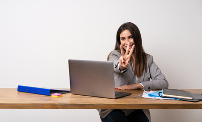 Business woman in a office happy and counting three with fingers