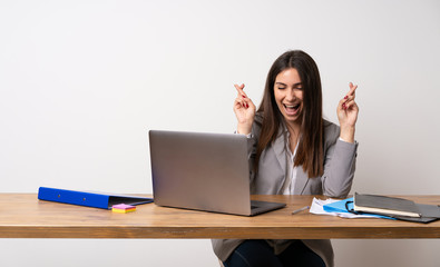 Business woman in a office with fingers crossing