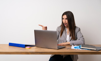 Business woman in a office pointing away