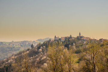 Scenic view of the medieval village of Bossolasco on the top of a hill in the Langhe region, Unesco World Heritage Site since 2014, in springtime at sunset, Piedmont, Italy 