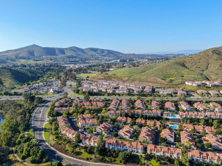 Fototapeta na wymiar Aerial view suburban neighborhood with identical villas next to each other in the valley. San Diego, California, USA. Aerial view of residential modern subdivision luxury house with swimming pool.
