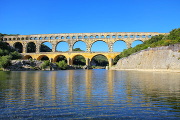 Fototapeta na wymiar Aqueduct Pont du Gard reflected in Gardon River, southern France