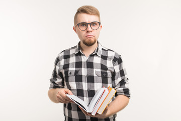 Exam, knowledge and education concept - Portrait of a student man holding books in his hands on white background