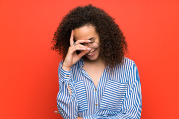 Dominican woman over red wall laughing