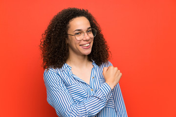 Fototapeta premium Dominican woman over red wall celebrating a victory