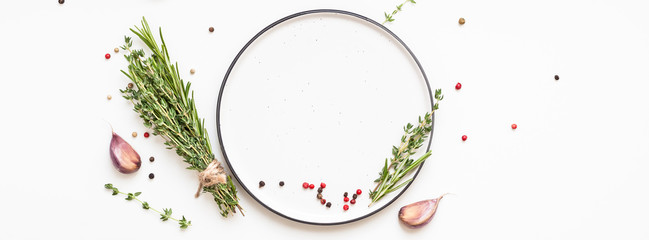 Empty plate with greens herbs and spices around - obrazy, fototapety, plakaty