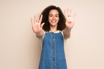 Dominican woman with overalls counting nine with fingers