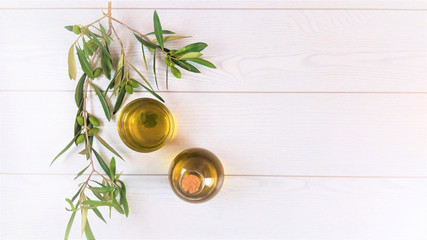 olive oil with a branch of green olives on white background